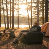 Person sitting on FREEIN Inflatable Camp Sofa Single at outdoor campsite